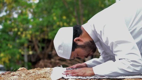 Young asian muslim man praying on sunset,Ramadan festival concept