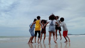 slow motion video shot of  African-American children are dancing and dancing on the beach, in the summer atmosphere.
