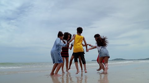 slow motion video shot of  African-American children are dancing and dancing on the beach, in the summer atmosphere.
