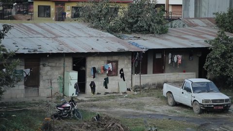 Kathmandu, Nepal - 27 November 2019: Everyday life in poor Nepali Indian areas. A male brings cardboard boxes into the house. Are standing on the street a car and a motorbike . Drying clothes on ropes
