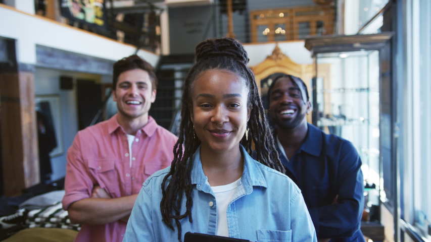 Portrait of smiling multi-cultural sales team in fashion store in front of clothing display - shot in slow motion | Shutterstock HD Video #1053662522