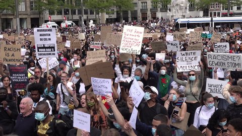 AMSTERDAM, NETHERLANDS – 1 JUNE 2020: Crowds of people attend anti racism and Black Lives Matter protest in Amsterdam, many wearing face masks due to Covid-19 coronavirus