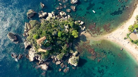 Aerial view of Isola Bella in Taormina, Sicily, Italy. Isola Bella is small island near Taormina, Sicily, Italy. Narrow path connects island to mainland Taormina beach in azure waters of Ionian Sea. 