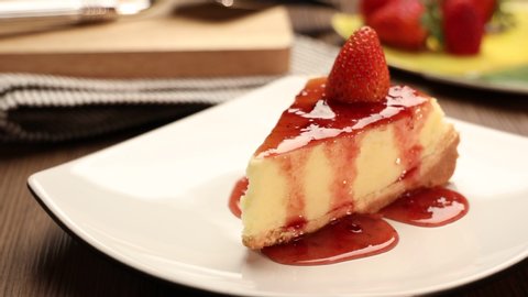 delicious slice of  strawberries cheesecake on a white plate on a wooden table, 4k.