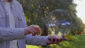 Unrecognizable man shows conceptual hologram with Americam Truck. Farmer on the background of the apple orchard in casual clothes with the technology of the future mobile screen - Powered by Shutterstock - Get 15% off with code: PIKWIZARD15