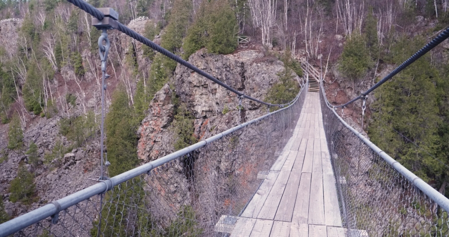 Mont-Brun, Quebec/Canada 05-23-2020: Swing bridge crossing the narrow lake at  Aiguebelle National Park near of city of Rouyn-Noranda 
