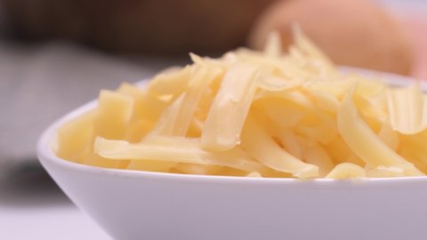 Cheese threads close up on white bowl with cheese bread background
