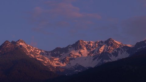 Spectacular sunset over the snowy peaks of the Italian Alps. 4K