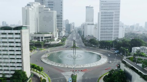 JAKARTA - Indonesia. May 19, 2020: Aerial view of quiet traffic near Hotel Indonesia Roundabout with skyscrapers during coronavirus quarantine in Jakarta city. Shot in 4k resolution