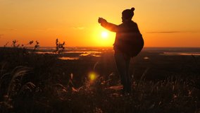 free Young girl tourist blogger records selfie video on top of the mountains using a smartphone with a beautiful landscape. Healthy cheerful woman travels at dawn and photography nature on phone.