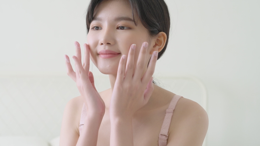 Beautiful young asian woman makeup of cosmetic for facial soft, girl hand touch face smooth applying cream and lotion for rejuvenation, beauty perfect with wellness, skin care and health concept. Royalty-Free Stock Footage #1053703250