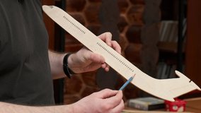 teacher holds brown wooden passenger airplane model fuselage in hand and shows structure with pencil slow motion closeup - Powered by Shutterstock - Get 15% off with code: PIKWIZARD15