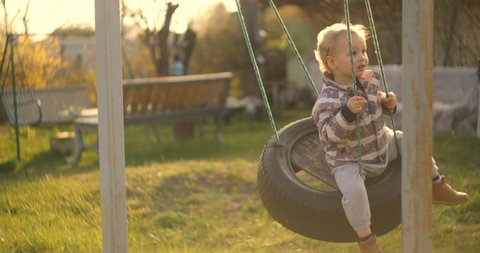 Little boy having fun on chain swing. Child on playground. swing Kids play outdoor. Smiling boy swinging on a rope at a playground.