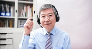 telework concept - Asian senior businessman is very happy to talking plans on a video meeting with gestures in the office