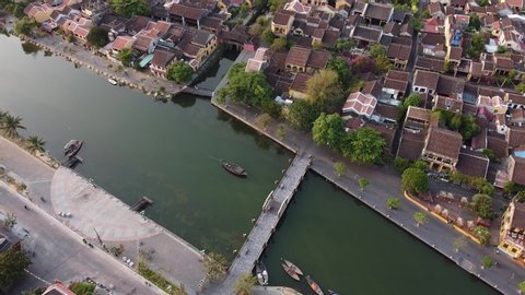 Aerial top down view of old heritage houses site, bridge and river in Hoi an town.