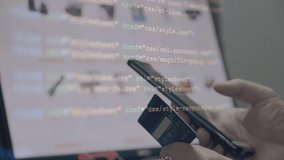 close up Shallow focus hand hold Credit Card and mobile phone with  and E-commerce website on monitor background with Coding overlay . Background for E-commerce and online shopping concept. - Powered by Shutterstock - Get 15% off with code: PIKWIZARD15