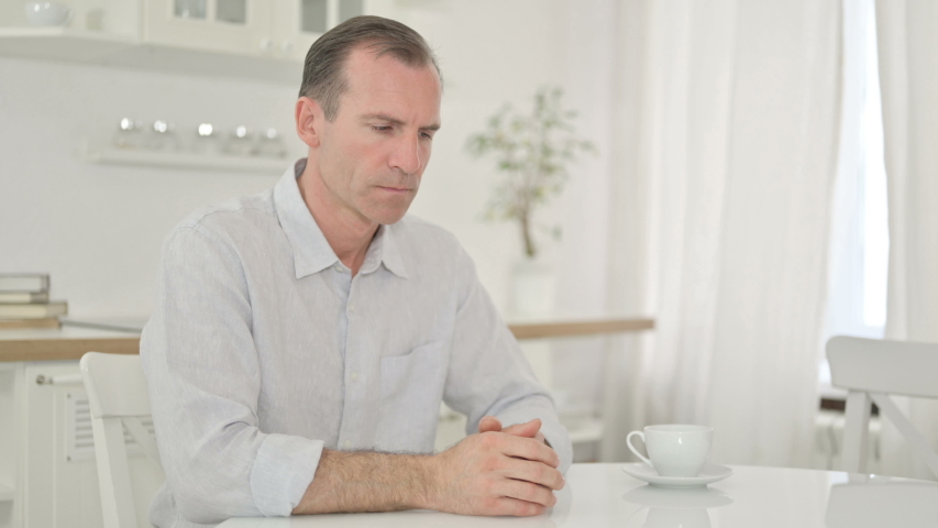 Stressed Middle Aged Man getting Worried at Home