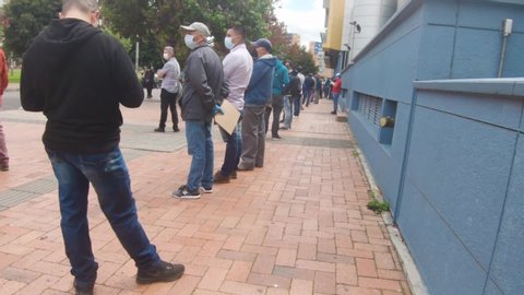 Bogotá / Colombia - Abril 20 2020:
line of people using medical masks at quarantine in mall plaza imperial suba of south america in coronavirus time, social disancing concept covid 19
