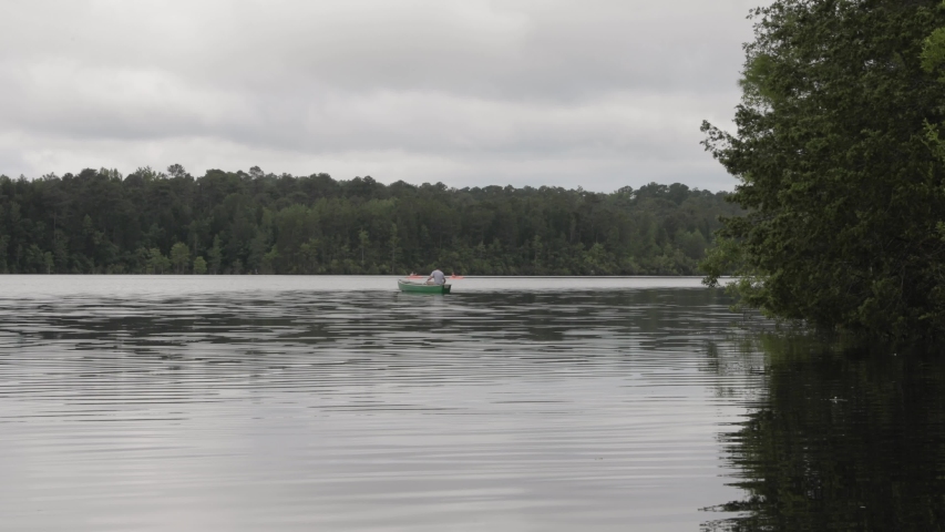 Canoe paddling in lake with kayaks in background