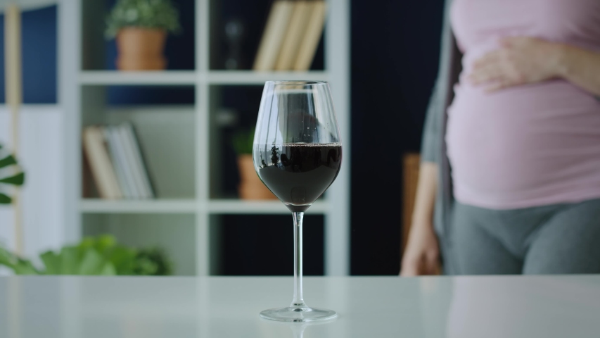 Video of pregnant woman grabbing a glass of red wine. Shot with RED helium camera in 8K   | Shutterstock HD Video #1053733409