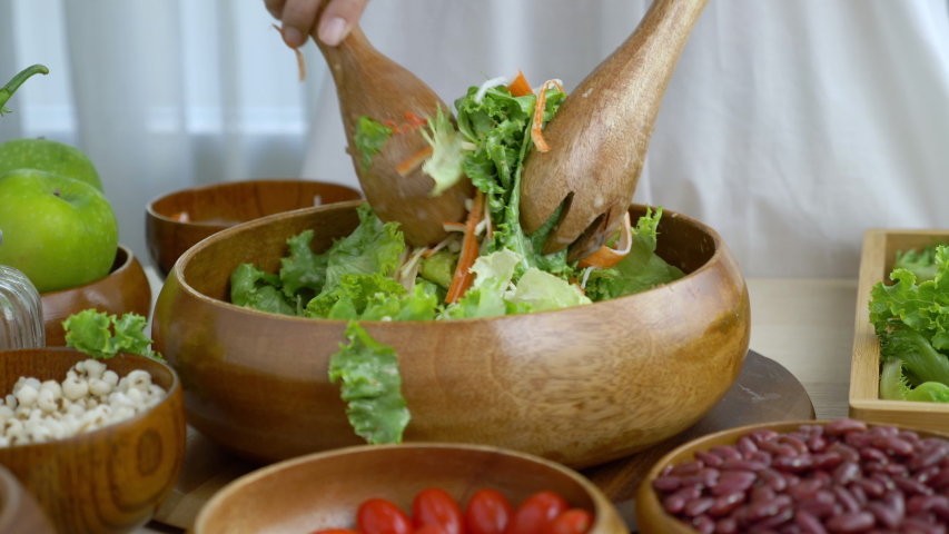 Hand woman chef Mixing Green Salad , Millet,Crab Stick In glass bowl. Breakfast fresh salad and clean vegetable can eat raw. Nutritious and enzymes in Salad mix leaves green vegetable can detox.  | Shutterstock HD Video #1053737972