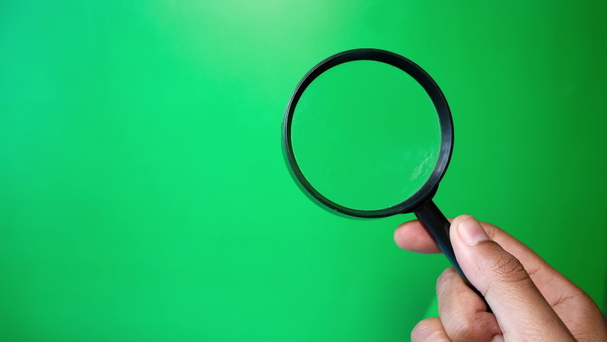 man's hand holding magnifying glass, Close up Royalty-Free Stock Footage #1053744122