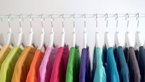  Close up of Colorful t-shirts on hangers, apparel background, Slider shot