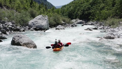 Aerial follow cam shot of dual kayak going down the emerald alpine river Soca, Slovenia