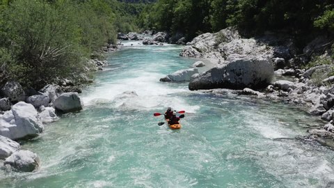 Aerial follow cam shot of dual kayak going down the emerald alpine river Soca, Slovenia