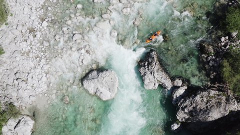 Aerial shot top down shot kayaking a big rapid on emerald alpine river Soca, Slovenia