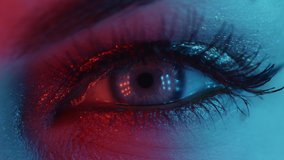 Extreme close up of human eye iris under neon light 4K. Female with beautiful makeup, glitter shadows and false lashes. Womens green eye contracting. Nightlife, night club concept. - Powered by Shutterstock - Get 15% off with code: PIKWIZARD15