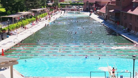 Glenwood Springs, USA - July 10, 2019: High angle view of famous Colorado natural hot springs pool in downtown with water and people swimming children diving