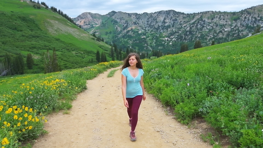 Albion Basin, Utah handheld front view pov of young woman hiker walking hik...