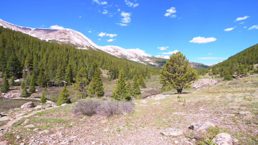 Independence Pass mining townsite buildings houses panoramic panning in White River National Forest in Colorado with green pine trees and snow mountain peaks