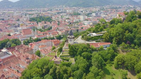 Dolly zoom. Graz, Austria. Clock Tower in Graz. The historic city center aerial view. Mount Schlossberg (Castle Hill), Aerial View, Departure of the camera