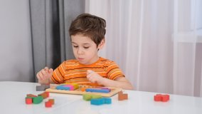 Close up of child's hands playing with colorful wooden bricks at the table. stock footage. Slow Motion video. Close up