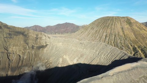 View from above, stunning aerial view of the Mount Batok and the Mount Bromo illuminated during a sunny day. Mount Bromo is an active volcano in East Java, Indonesia.