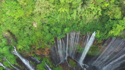 View from above, stunning aerial view of the Tumpak Sewu Waterfalls also known as Coban Sewu. Tumpak Sewu Waterfalls are a tourist attraction in East Java, Indonesia.