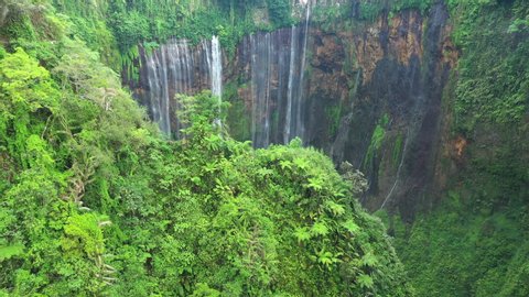 View from above, stunning aerial view of the Tumpak Sewu Waterfalls also known as Coban Sewu. Tumpak Sewu Waterfalls are a tourist attraction in East Java, Indonesia.