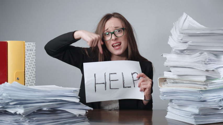 Nervous breakdown at work, screaming office worker with glasses sitting at the table among the piles of unfilled documents and file folders. Overtime working day, accounting process, office career | Shutterstock HD Video #1053783923