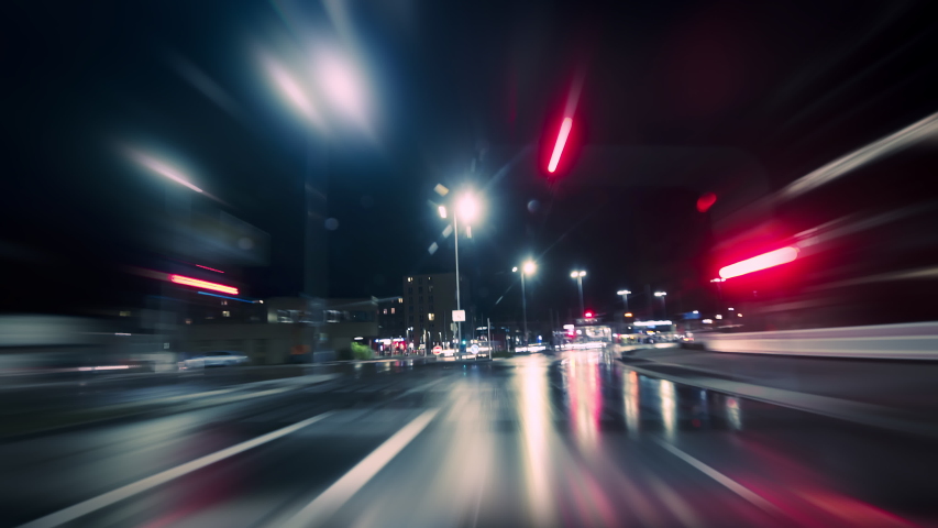 Driving fast on the German Autobahn and through a town at night, dynamic time lapse video with motion blur 