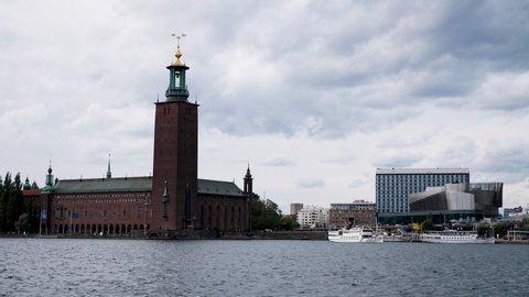 Time lapse of boat traffic on waterfront of landmark town hall building in Stockholm