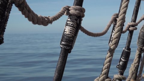Shrouds and ropes of an old sailboat in the open sea.