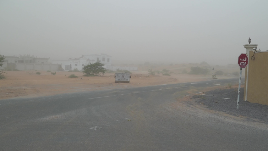 Dust storm in the Middle East blows sand across the road of a rural area in the United Arab Emirates.  Royalty-Free Stock Footage #1053793202