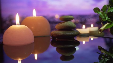 Spa Still Life, Stones massage and Water Relax. Close up. Relaxing view of burning candles. water reflection on blurred background. Relaxation, meditation, peace and quiet.	