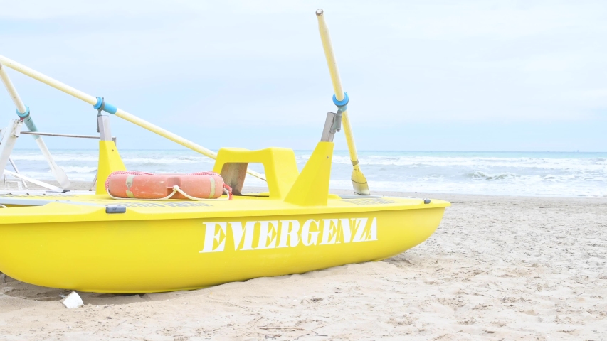 Rescue catamaran on a sandy beach. On board inscription emergenza (emergency) The promenade of the city beach of Rimini. Italy.