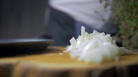 Close-up of placing a pan with onion