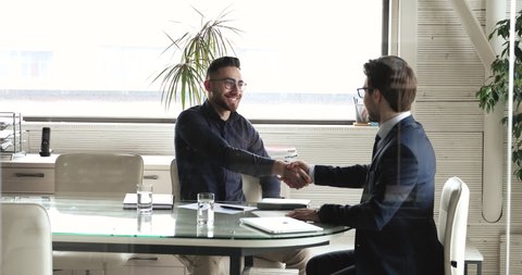 Two arabian and caucasian businessmen handshaking at business meeting making agreement. Arabic executive shake hand of partner, advisor or manager make bank loan insurance investment deal concept.