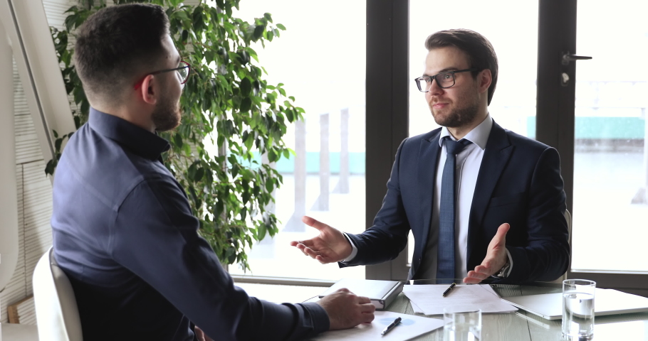Confident caucasian businessman handshaking male arab eastern partner at office meeting. Two multiethnic professional executives shake hands establishing partnership, investment agreement concept. Royalty-Free Stock Footage #1053812264