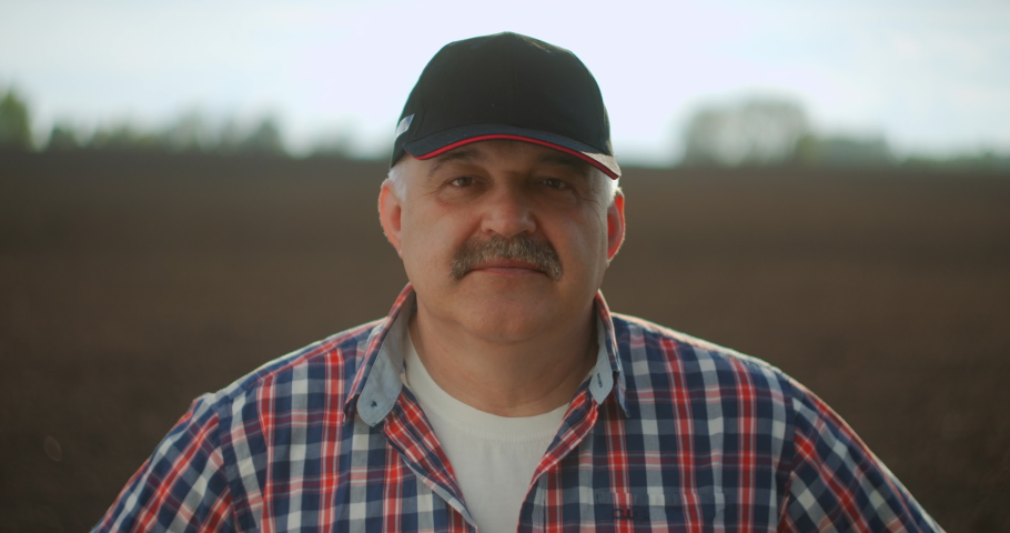 Slow motion Close-up Portrait A tractor driver looks at the camera after a working day at sunset | Shutterstock HD Video #1053820121